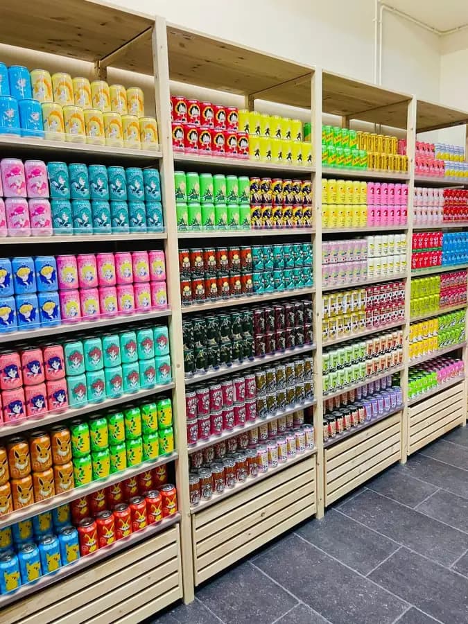 Anime-themed Japanese drink cans including Pokémon and Sailor Moon at OKASHI Group Wrocław