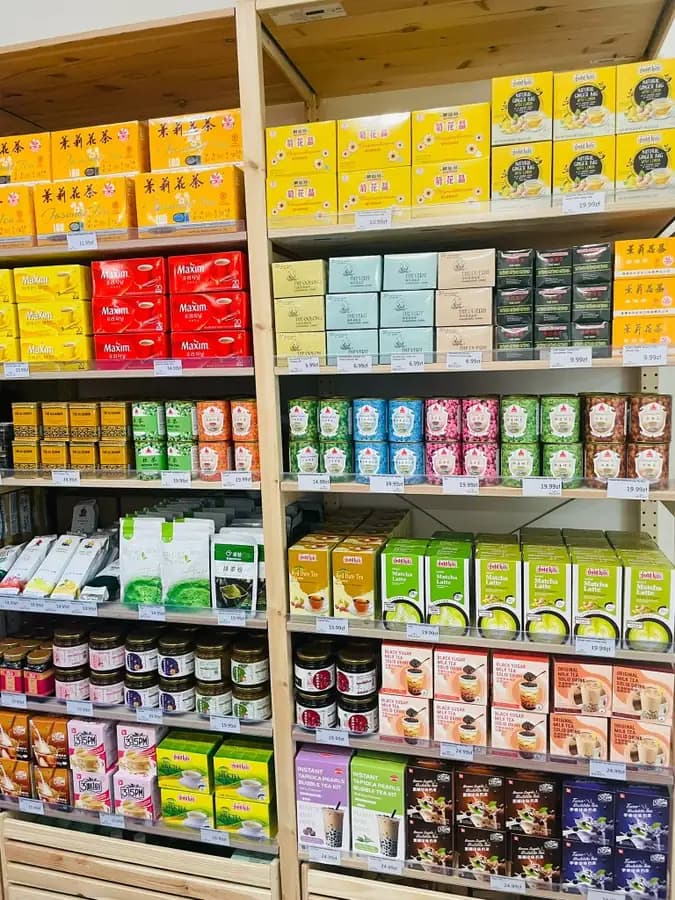 Matcha latte, jasmine tea and bubble tea kits on shelves at OKASHI Group supermarket