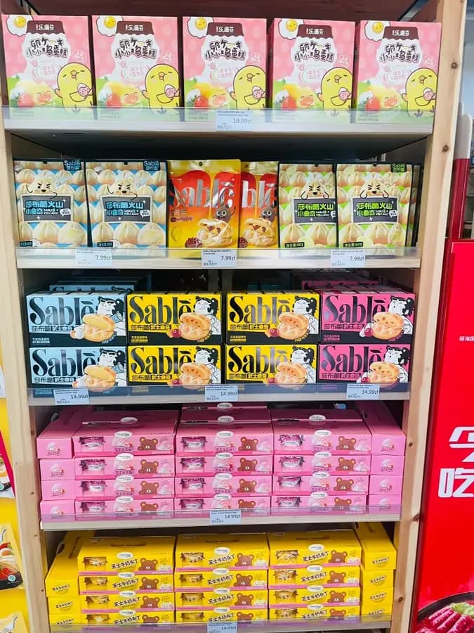 Imported Asian cookies and cakes on wooden retail shelves at OKASHI Group Wrocław