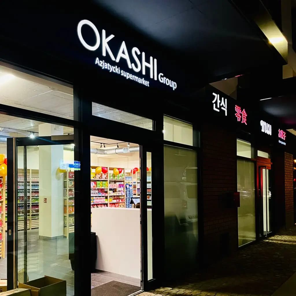 OKASHI Group Asian supermarket storefront at night in Wrocław, with Azjatycki supermarket signage